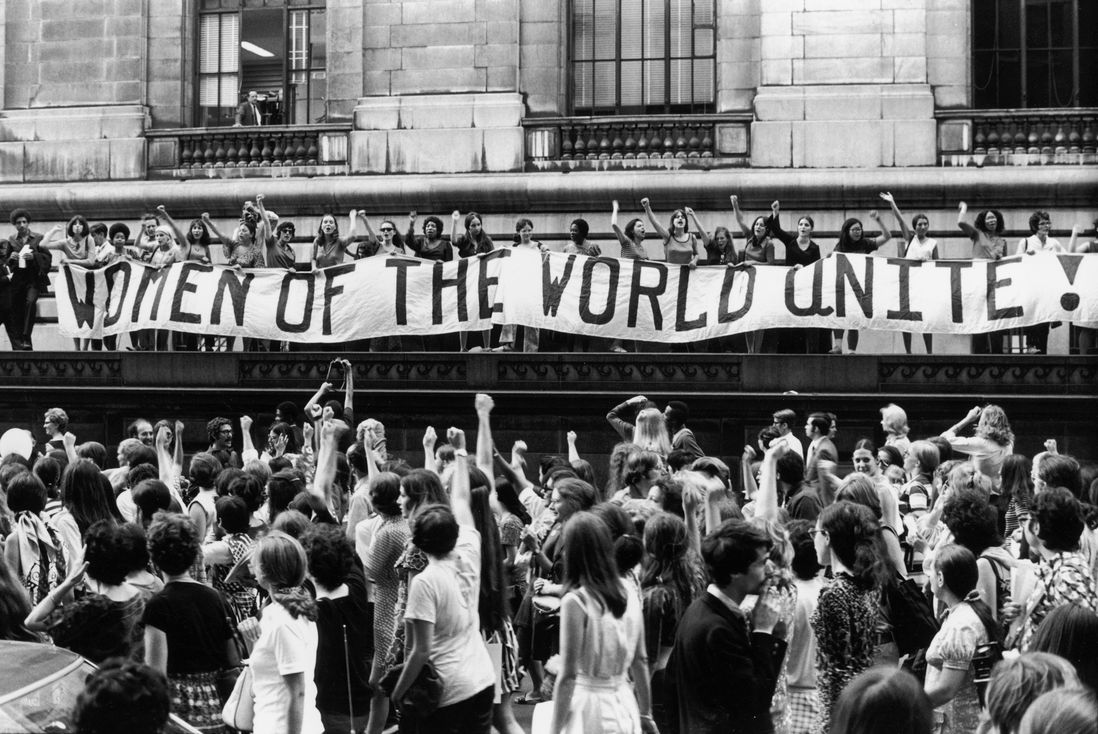 To commemorate the fiftieth anniversary of women’s suffrage in the United States, an estimated twenty thousand women march along Fifth Ave., here past a banner that reads, ‘‘Women of the World Unite!”, August 26, 1970<br/>